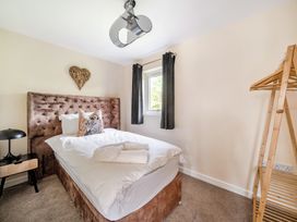 A bedroom with a bed and bedside lamp at Poker Lodge Near Brigg
