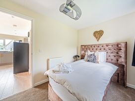 A bedroom with a bed and a doorway leading to another room at Poker Lodge Near Brigg