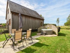 An outdoor space with a hot tub and seating at Poker Lodge near Brigg