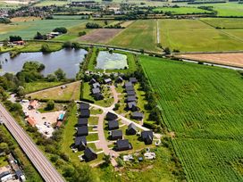 An aerial view of houses and a pond at Poker Lodge near Brigg