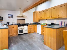 A kitchen with wooden cabinets and appliances at Oakdene in Keswick
