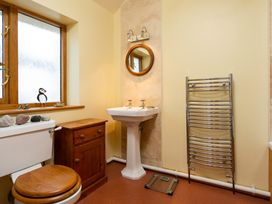 A bathroom with a sink, toilet, and mirror at Oakdene in Keswick