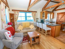 A living room with a sofa and kitchen area at Casa Mia Goodwick