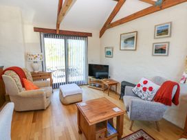 A living room with a sofa, table, and tv at Casa Mia in Goodwick