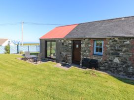 A cottage with a table and chairs on the lawn at Casa Mia Goodwick