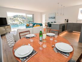 A dining room with a circular table and view of the water at Galvayne in Dartmouth