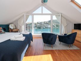 A bedroom with a bed and armchairs overlooking a view at Galvayne in Dartmouth