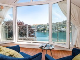A living room with chairs and a table overlooking the water at Galvayne Dartmouth