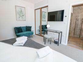 A bedroom with a bed, couch and mirror in Galvayne Dartmouth