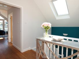 A hallway with a wooden table and a flower vase at Galvayne in Dartmouth