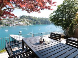 An outdoor terrace with a table and chairs overlooking the waterfront at Galvayne in Dartmouth