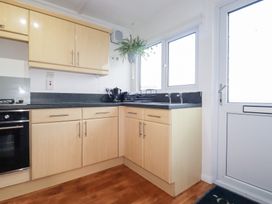 A kitchen with cabinets and sink at Ms Merryn 37 St. Cadocs