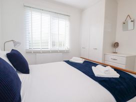 A bedroom with a bed and wardrobe at Ms Merryn 37 St. Cadocs