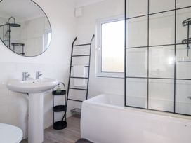 A bathroom with a sink, bathtub, shower, and mirror at Ms Merryn 37 St. Cadocs