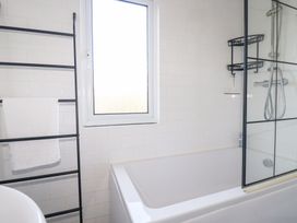 A bathroom with a bathtub, towel rack, and shower at Ms Merryn 37 St. Cadocs