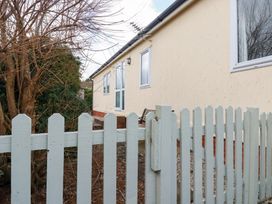 A house exterior with a fence and trees at Ms Merryn 37 St. Cadocs