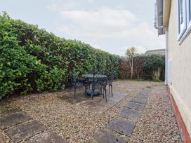 A garden with a stone table and chairs surrounded by hedges at Ms Merryn 37 St. Cadocs