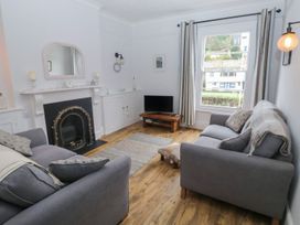 A living room with a fireplace and television at The English School, Flat 2 in Dartmouth