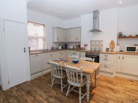 A kitchen with a table and chairs at The English School, Flat 2 in Dartmouth