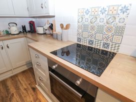 A kitchen with a stove and appliances at The English School, Flat 2 in Dartmouth