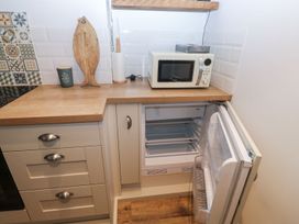 A kitchen area with a microwave and refrigerator at The English School, Flat 2 Dartmouth