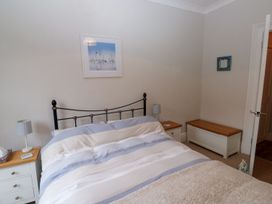 A bedroom with a bed and storage bench at The English School, Flat 2 in Dartmouth