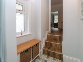 A hallway with a storage bench and stairs at The English School, Flat 2 in Dartmouth
