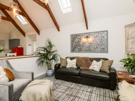 A living room with a sofa and plant at The Old Byre in Falmouth