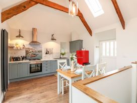 A kitchen with a dining table and red refrigerator at The Old Byre in Falmouth
