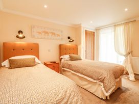 A bedroom with two beds and a nightstand at The Old Byre in Falmouth