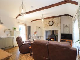 A living room with a sofa, fireplace, and television at The Forge in Falmouth