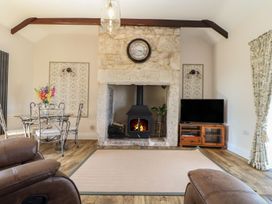 A living room with a fireplace and dining table at The Forge in Falmouth