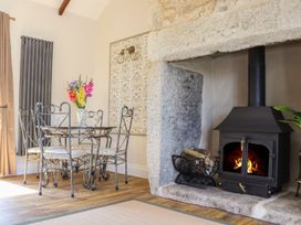 A dining room with a table and chairs near a fireplace at The Forge in Falmouth