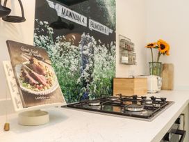 A kitchen with a gas stove and cooking book at The Forge in Falmouth
