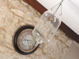 A clock and a glass light fixture on a stone wall at The Forge in Falmouth