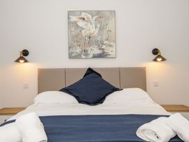 A bedroom with a bed and wall art at The Forge in Falmouth