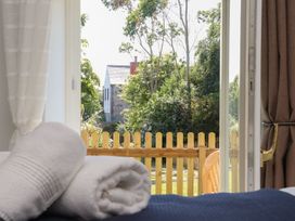 A bedroom view with towels and a window facing a garden at The Forge in Falmouth