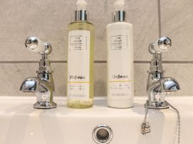 A sink with hand wash and hand lotion bottles at The Forge in Falmouth
