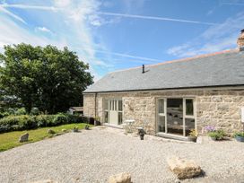 An outdoor area with a stone house, table, and chairs at The Forge in Falmouth
