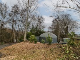 A yurt surrounded by trees and plants in a wooded area at Lakeview Yurt Beckford near Tewkesbury