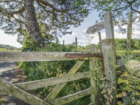 A wooden gate with a signpost and trees at Cottage No 9 in Keswick