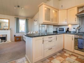 A kitchen with cabinets and appliances at 1 Ocean Terrace in Ilfracombe