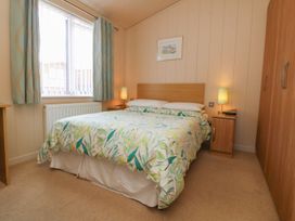 A bedroom with a bed and bedside table at 1 Ocean Terrace Ilfracombe