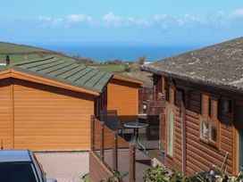 An outdoor area with cabins and a table with chairs at 1 Ocean Terrace in Ilfracombe