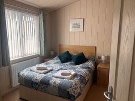 A bedroom with a bed and bedside tables at 1 Ocean Terrace, Mullacott near Ilfracombe