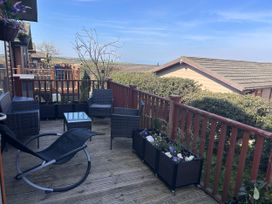 An outdoor seating area with chairs and table at 1 Ocean Terrace in Mullacott near Ilfracombe