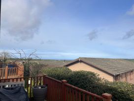 View from a deck with trees and houses in the foreground at 1 Ocean Terrace Mullacott near Ilfracombe