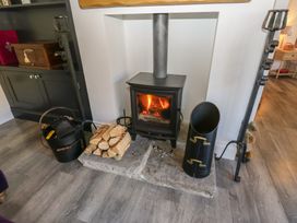A fireplace with logs and a bucket at The Summerhouse in 
