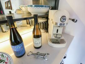 A kitchen counter with wine bottles and an espresso machine at The Summerhouse 