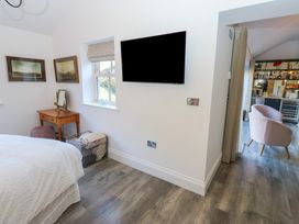 A bedroom featuring a bed, television, and a table with a mirror at The Summerhouse in 
